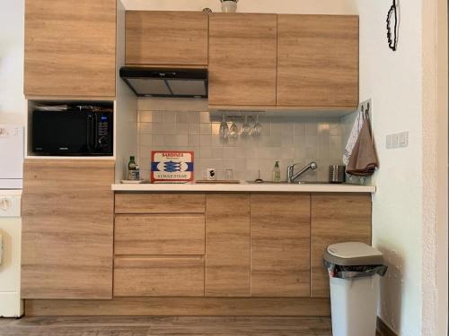 une cuisine avec des armoires en bois et un évier dans l'établissement Appartement au bord de mer, à Ghisonaccia