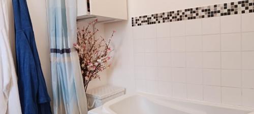 une salle de bain avec une baignoire blanche et un lavabo dans l'établissement Jolie maison avec jardin clos - Fontainebleau Héricy, 35 min Paris, à Héricy
