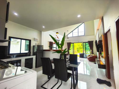 a kitchen and living room with a table and chairs at Sunny Petite Villa Close to Beach in Koh Samui