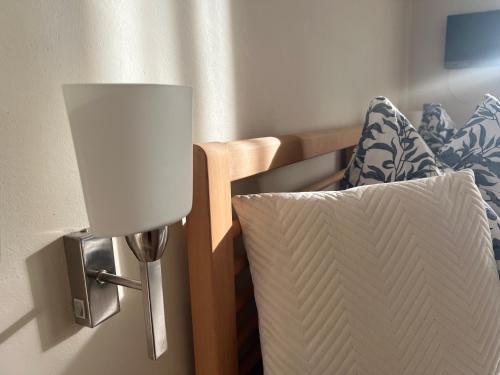 a lamp on a wall next to a bed at Gästezimmer La Storia in Rosegg