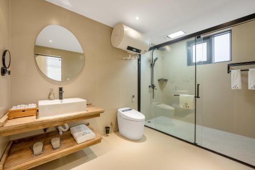 a bathroom with a sink toilet and a mirror at Xizhou Feng Shangju in Dali