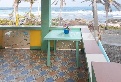 a green table sitting on a balcony with the beach at RedDoorz at Precious Dem Beach Resort Pagudpud in Aggao