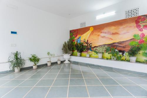 a room with potted plants and a painting on the wall at Emperor Palace A Heritage villa in Udaipur