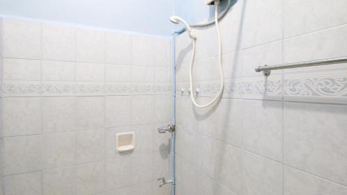 a shower in a bathroom with white tiles at RedDoorz at Precious Dem Beach Resort Pagudpud in Aggao