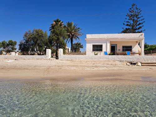 a white house on the beach with the water at Villino Relax in Portopalo