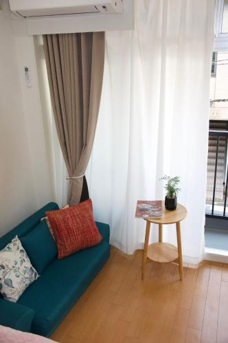 a living room with a blue couch and a table at 全新装修南品川haven春 in Tokyo