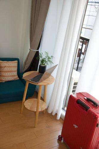 a red suitcase sitting next to a table with a plant at 全新装修南品川haven春 in Tokyo