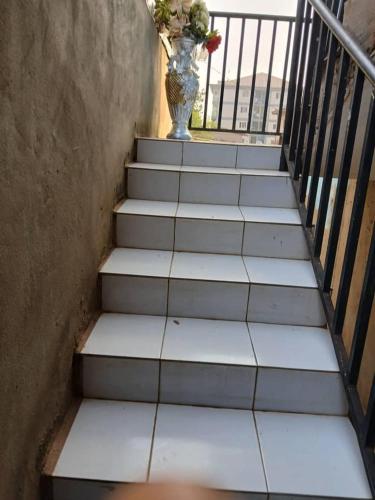 a staircase with a vase of flowers and a vase at Ultra modern suite in Yaoundé in Yaoundé