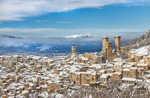 a city covered in snow with mountains in the background at Mario's Sweet Home in Sulmona