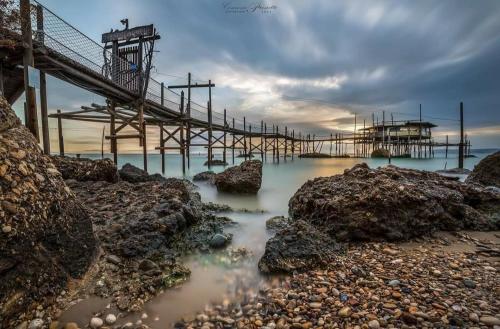 a dock in the ocean with rocks and the water at Mario's Sweet Home in Sulmona