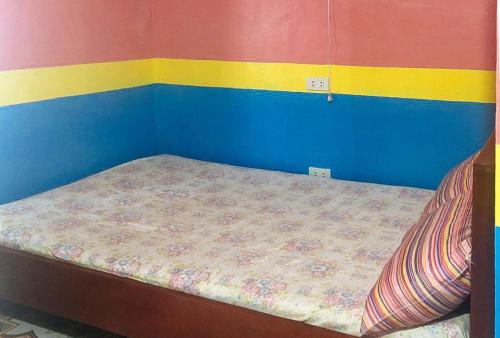 a small bed in a room with colorful walls at RedDoorz at Precious Dem Beach Resort Pagudpud in Aggao