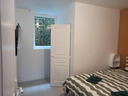 a bedroom with a bed and a window at Appartement 2 à 4 personnes proche de la mer in Saint-Jean-le-Thomas