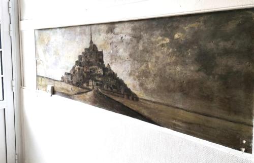 a painting of a building on the side of a wall at Appartement 2 à 4 personnes proche de la mer in Saint-Jean-le-Thomas