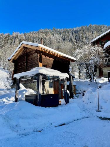 a cabin with a snow covered roof in the snow at Walliser Stadel in Fieschertal