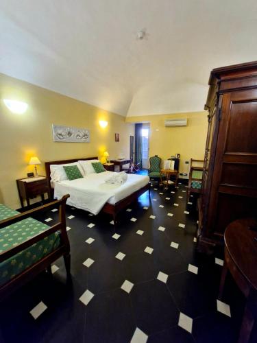a bedroom with a bed and chairs in a room at Palazzo Vescovile Hotel in Noli