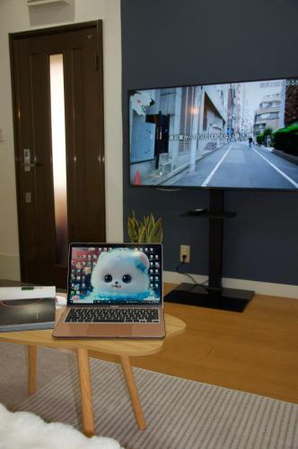 a laptop computer sitting on a table in front of a tv at 全新装修南品川haven春 in Tokyo