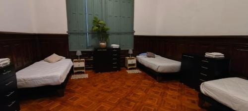 a room with three beds in a room at Casa Marina Huérfanos in Santiago