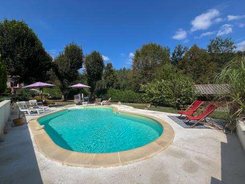 - une piscine avec 2 chaises longues, une table et des chaises dans l'établissement Charmante maison avec piscine en pleine campagne, à Bajamont