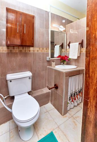 a bathroom with a toilet and a sink at Diani Beach Gold Apartments in Diani Beach