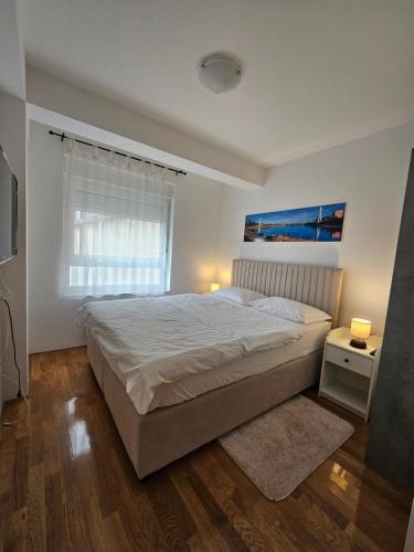 a bedroom with a large bed and a window at OnPoint Apartmani in Osijek