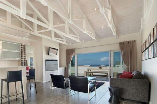 a living room with a view of the ocean at Spatalla Holiday Homes in Kleinmond