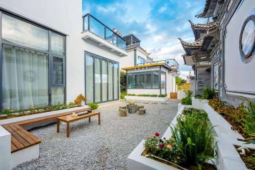 a courtyard of a house with a bench and plants at Xizhou Feng Shangju in Dali