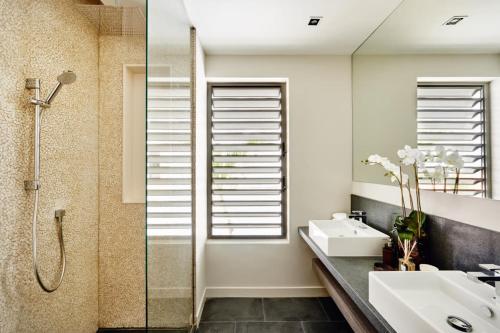 a bathroom with a shower and a sink and a mirror at The Pearl of Jan Thiel villa with private pool gym and game room in Willemstad