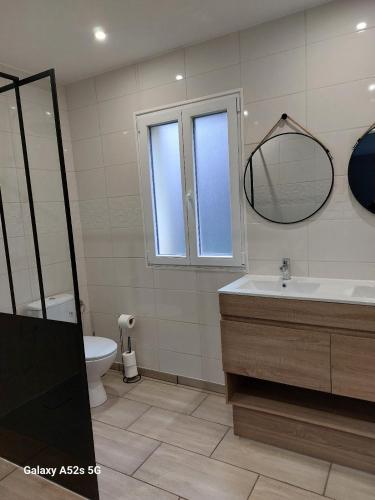 une salle de bain avec un lavabo, des toilettes et un miroir dans l'établissement Maison en Périgord, à Carsac-Aillac