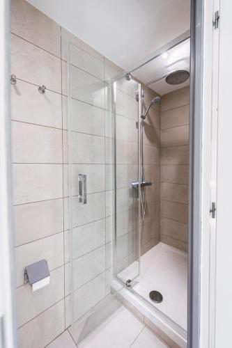 une douche avec une porte vitrée dans une salle de bain dans l'établissement Le petit répit châteaux Islette -Azay - CNPE, à Cheillé