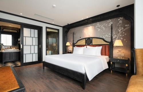 a bedroom with a large white bed and a bathroom at Luxe Paradise Premium Hotel and Spa in Hanoi