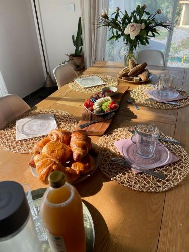 ein Holztisch mit Tellern voller Essen darauf in der Unterkunft Chambre d'hôtes Les Calades in Lardier-et-Valença
