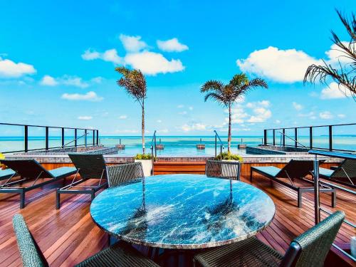 a patio with a table and chairs and the ocean at Flats pé na areia Alta Garden in João Pessoa