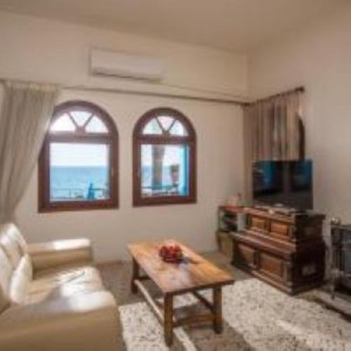 a living room with a couch and a coffee table at Exclusive Seaside Retreat with Shared Pool & Private Beach Access in Palaiokastro