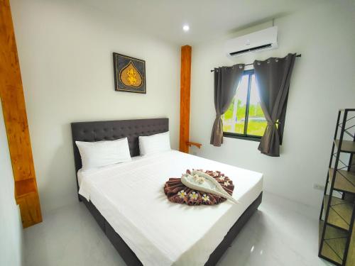 a bedroom with a bed with a plate of food on it at Sunny Petite Villa Close to Beach in Koh Samui