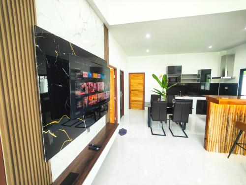 a living room with a television and a dining room at Sunny Petite Villa Close to Beach in Koh Samui