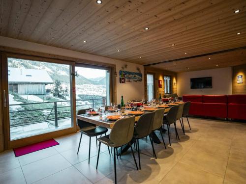 une salle à manger avec une longue table et des chaises dans l'établissement Chalet 6 pièces neuf, 12 pers, 3 sdb, parking, terrasse, proche remontées - FR-1-676-193, à Châtel