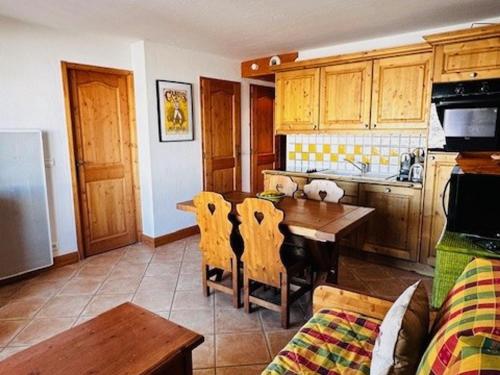 une cuisine avec une table en bois et une salle à manger dans l'établissement Charmant appart 6 pers, skis aux pieds, piscine et parking privé à Arc 1800 - FR-1-411-947, à Bourg-Saint-Maurice
