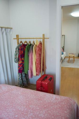 a room with a bed and a rack of clothes at 全新装修南品川haven春 in Tokyo