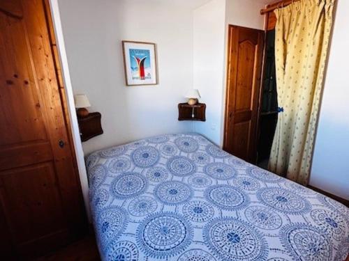 une chambre avec un lit bleu et blanc dans une pièce dans l'établissement Charmant appart 6 pers, skis aux pieds, piscine et parking privé à Arc 1800 - FR-1-411-947, à Bourg-Saint-Maurice