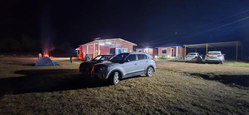 a white car parked in front of a house at night at Yashovana Nature Stay Gokarna in Gokarna