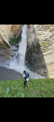a person taking a picture of a waterfall at Rupi Rani Home Stay in Gushāl