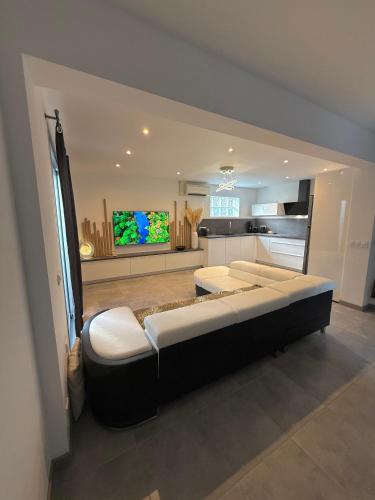 - un grand salon avec 2 lits et une télévision dans l'établissement Villa LEOVI Superbe logement 3 pieces - 7 personnes, à 100m plage la Faviere, à Bormes-les-Mimosas