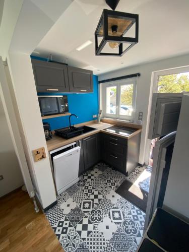 Il comprend une petite cuisine dotée de carrelage noir et blanc. dans l'établissement Maison Quiberon 4-6 Pers proche plage - garage privé, à Quiberon