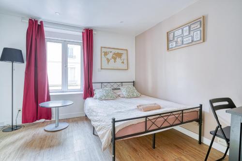 a bedroom with a bed and a window with red curtains at Abelia-Confort et Sérénité au coeur de la ville in Palaiseau