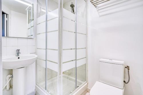 a bathroom with a shower and a toilet and a sink at Abelia-Confort et Sérénité au coeur de la ville in Palaiseau