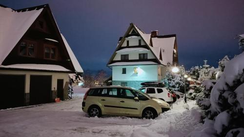 a car parked in the snow in front of a house at Dom Wypoczynkowy Słoneczny in Białka Tatrzanska