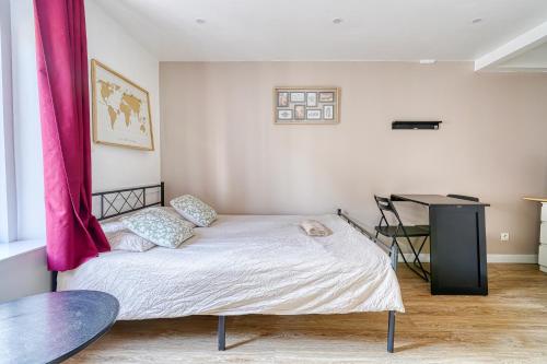 - une chambre avec un lit et un rideau rose dans l'établissement Abelia-Confort et Sérénité au coeur de la ville, à Palaiseau