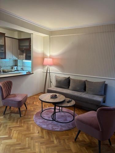 a living room with a couch and a table and chairs at Lovely square apartment Purple Velvet 43 Macedonia Stree in Skopje