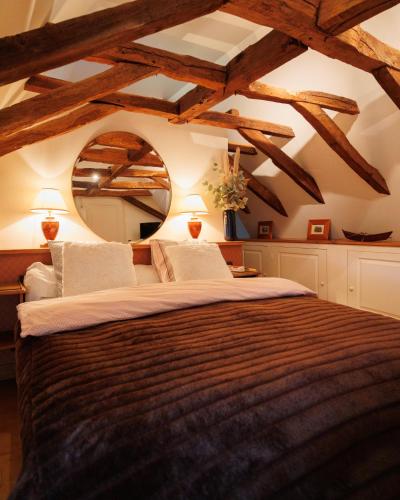 - une chambre avec un grand lit et des plafonds en bois dans l'établissement Domaine de la Rocque, à Liorac