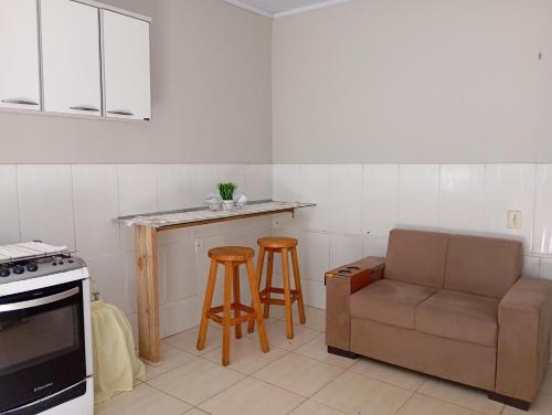 a kitchen with a couch and a table and stool at Apto 4 Bom Preco in Riacho Fundo